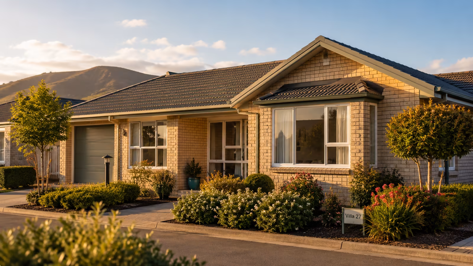 Photograph of a New Zealand retirement villa exterior in warm afternoon light.